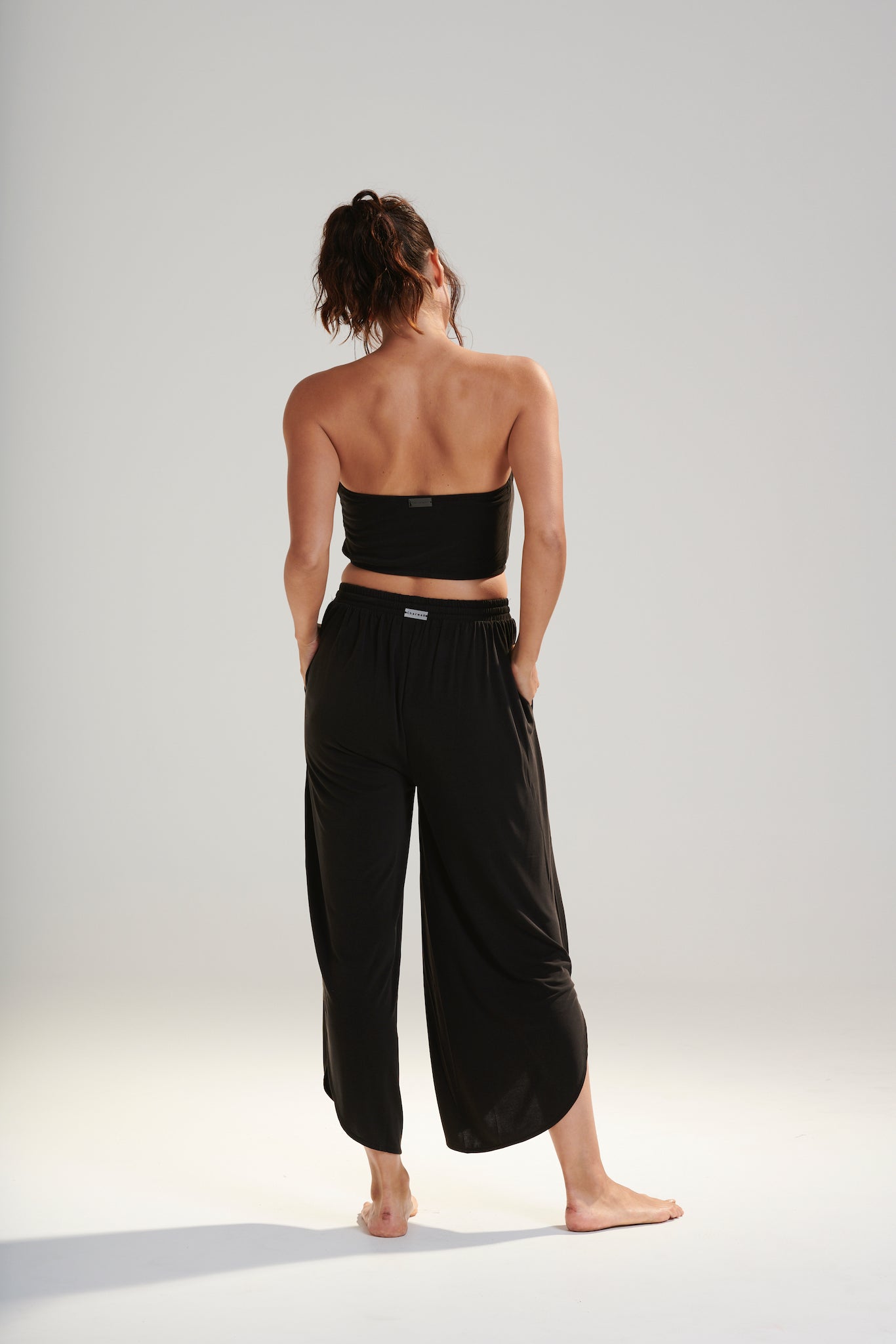 BELU PANT DARK WASHED BLACK LUXURY LOUNGEWEAR RELAXED KNIT PANTS WITH ELASTIC WAIST AND PETAL HEM BACK VIEW